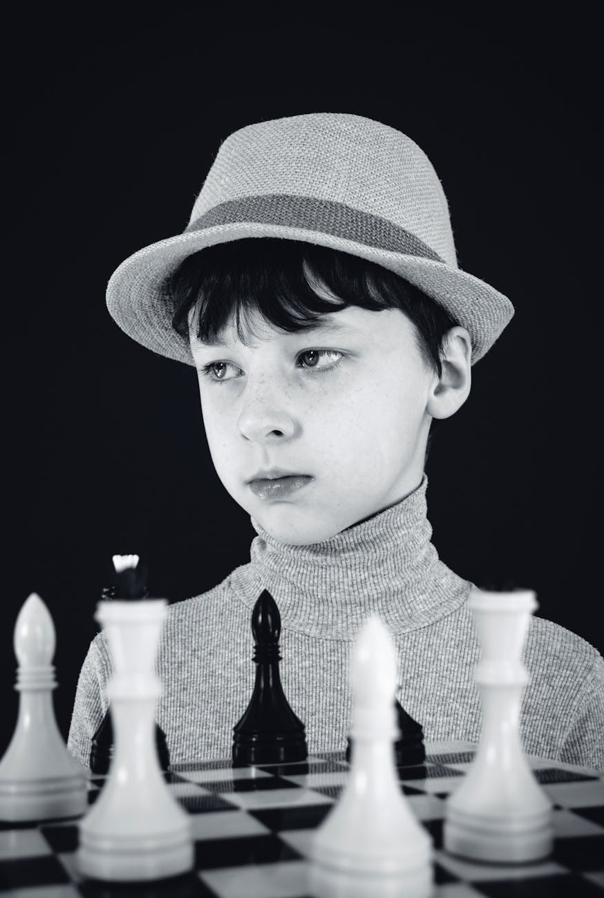 child sitting near chess board