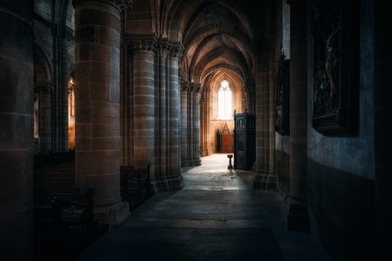 a dark hallway with a bench in the middle of it
